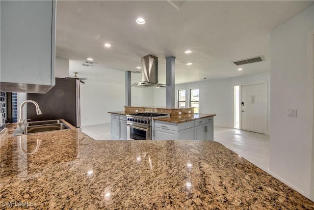 kitchen featuring sink, dark stone counters, white cabinets, stainless steel appliances, and exhaust hood