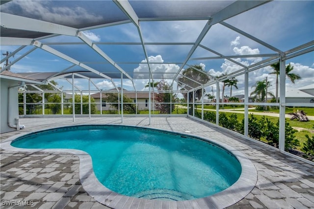 view of swimming pool featuring a patio area and glass enclosure