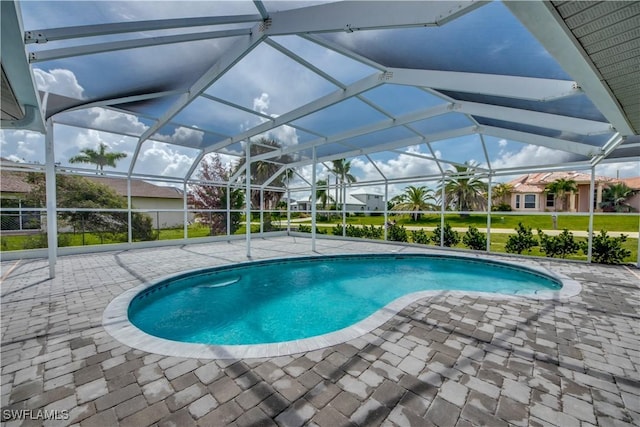 view of swimming pool featuring a patio area and glass enclosure