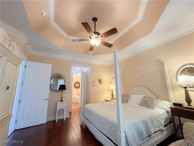 bedroom with ceiling fan, dark hardwood / wood-style floors, connected bathroom, ornamental molding, and a raised ceiling