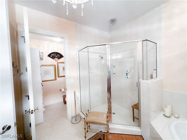 full bathroom featuring tile patterned flooring, a shower stall, and a garden tub