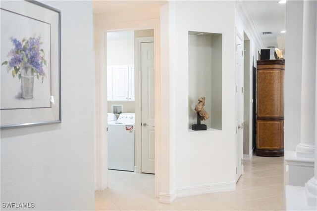 corridor with light tile patterned flooring and washer / dryer