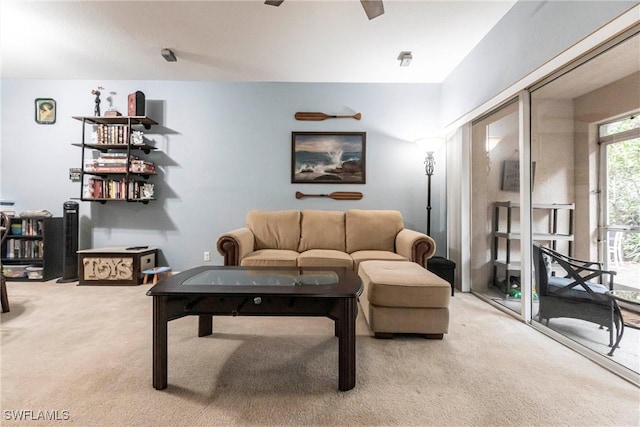 carpeted living room with ceiling fan