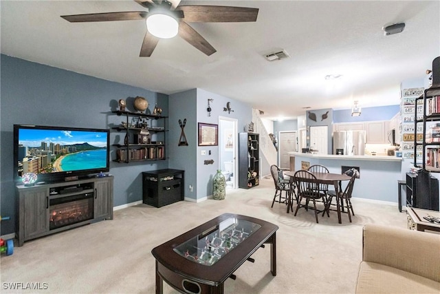 carpeted living room with ceiling fan