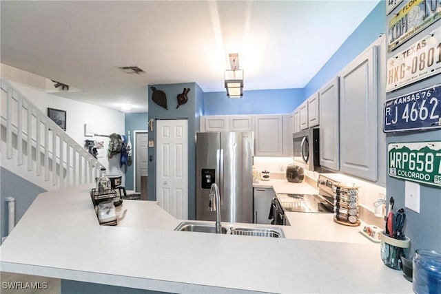 kitchen featuring stainless steel appliances, sink, and kitchen peninsula