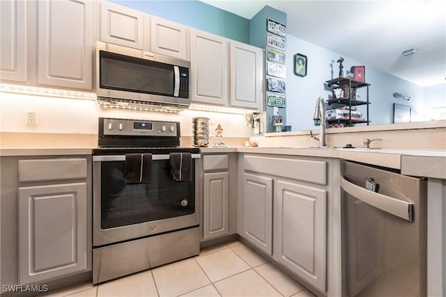 kitchen featuring white cabinetry, light tile patterned floors, stainless steel appliances, and kitchen peninsula