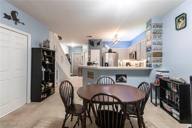 carpeted dining room with sink