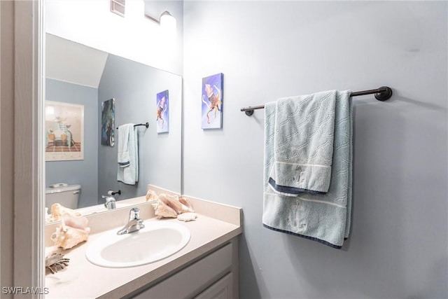 bathroom featuring vanity and toilet