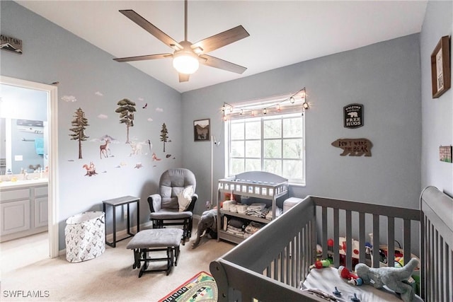 bedroom with ceiling fan, ensuite bath, carpet, and a crib