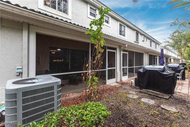 back of house featuring a sunroom and central AC unit