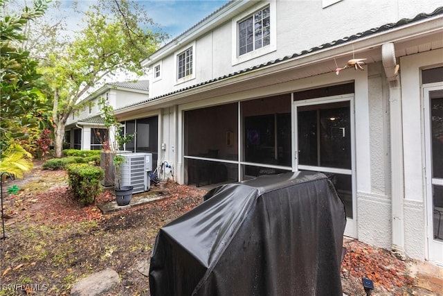 view of side of property with a sunroom and central AC