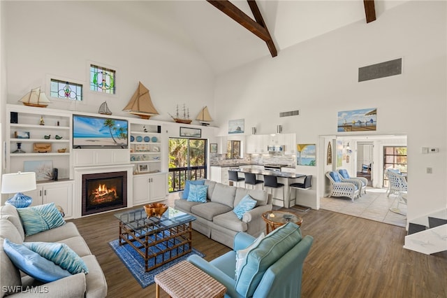 living room featuring hardwood / wood-style flooring, high vaulted ceiling, and beamed ceiling