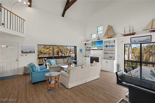 living room with hardwood / wood-style flooring, beam ceiling, and high vaulted ceiling