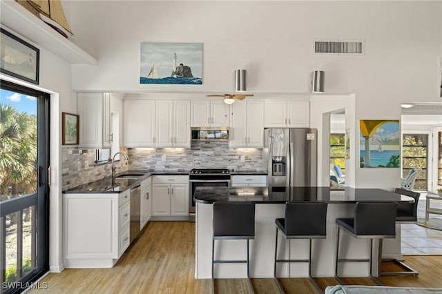 kitchen with white cabinetry, sink, backsplash, and appliances with stainless steel finishes