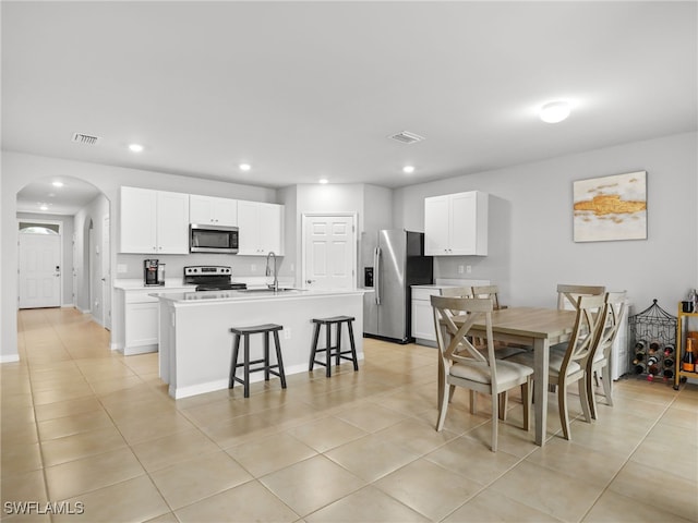 dining space featuring sink and light tile patterned floors