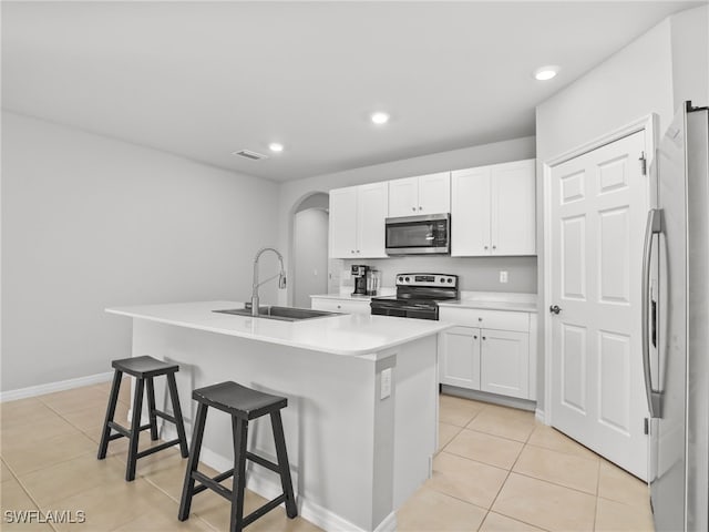 kitchen with sink, a center island with sink, white cabinets, and appliances with stainless steel finishes