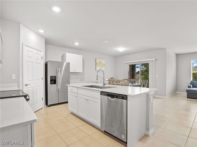 kitchen with white cabinetry, stainless steel appliances, sink, and a center island with sink