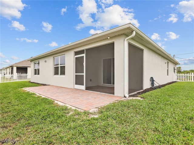 back of property featuring a lawn and a patio area