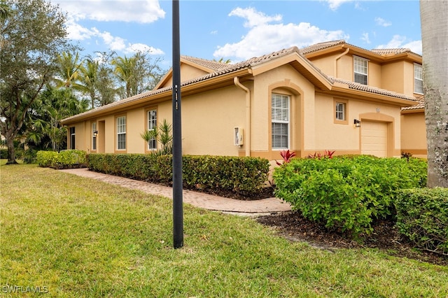 view of property exterior featuring a garage and a yard