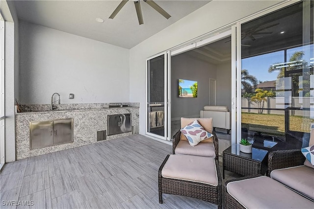 deck with visible vents, area for grilling, a sink, and a ceiling fan