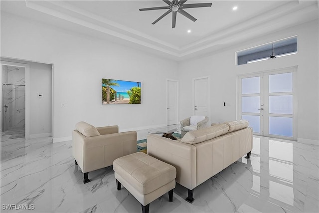 living area featuring marble finish floor, a high ceiling, and a ceiling fan