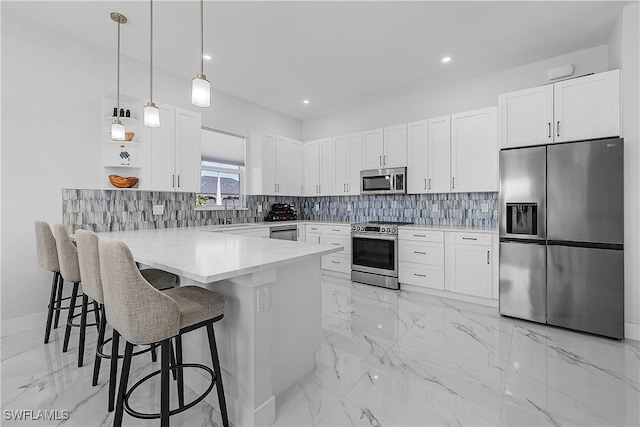 kitchen with decorative backsplash, a breakfast bar area, a peninsula, marble finish floor, and stainless steel appliances