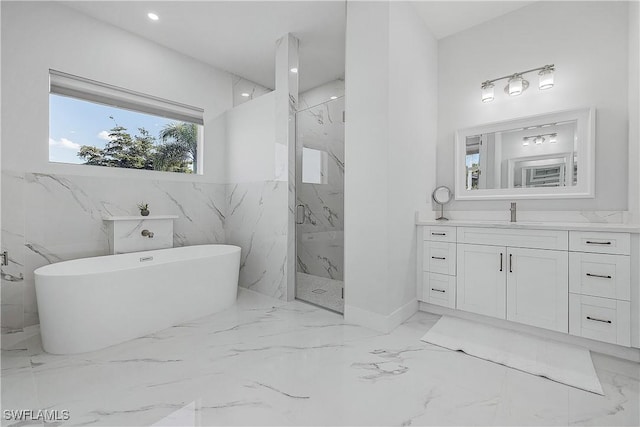 bathroom with marble finish floor, a marble finish shower, recessed lighting, vanity, and a freestanding tub