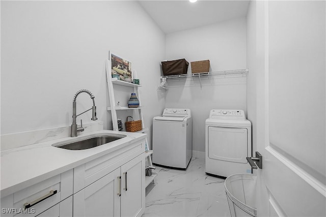 washroom with marble finish floor, washing machine and clothes dryer, a sink, and cabinet space