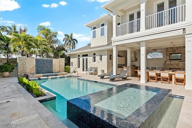 view of swimming pool featuring a bar, a patio, and an in ground hot tub