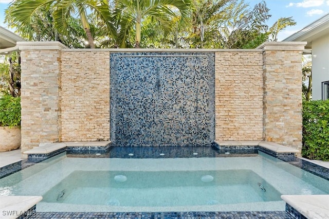 view of swimming pool featuring a hot tub