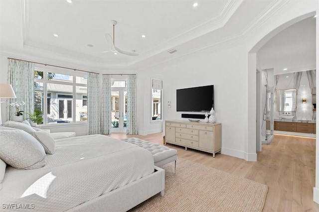 bedroom with ornamental molding, ceiling fan, light hardwood / wood-style floors, and a tray ceiling