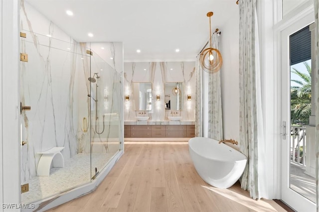 bathroom featuring vanity, separate shower and tub, wood-type flooring, and tile walls