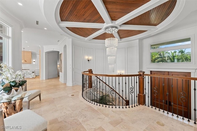 corridor with an inviting chandelier, ornamental molding, coffered ceiling, wooden ceiling, and beam ceiling