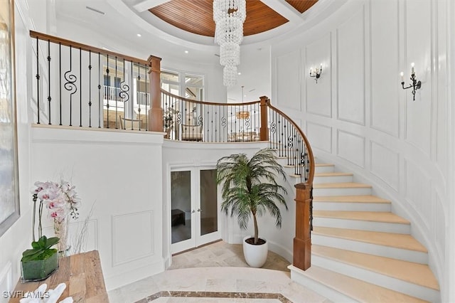 stairs featuring a notable chandelier and ornamental molding