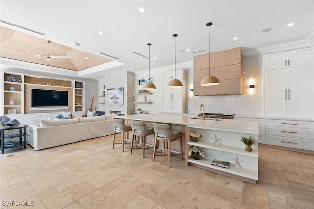 kitchen featuring a large island, decorative light fixtures, a breakfast bar area, and white cabinets