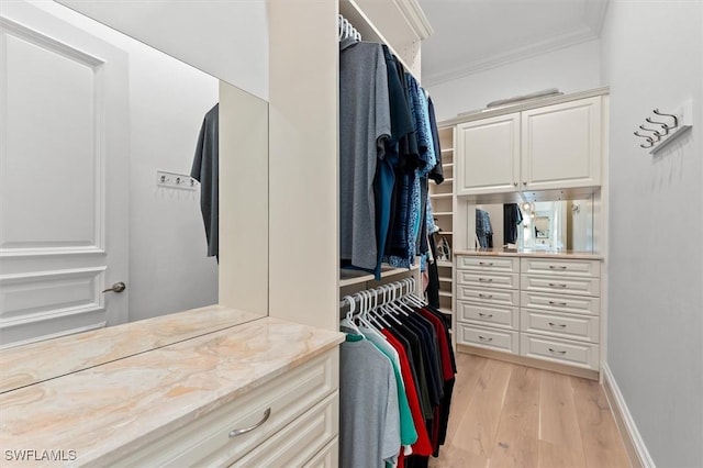 walk in closet with light hardwood / wood-style floors