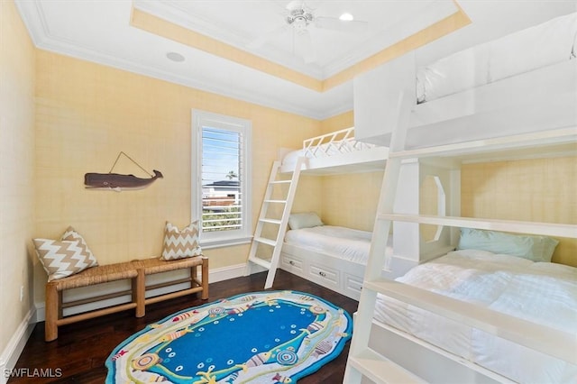 bedroom with hardwood / wood-style flooring, ceiling fan, ornamental molding, and a raised ceiling