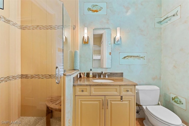 bathroom featuring vanity, a shower with shower door, and toilet