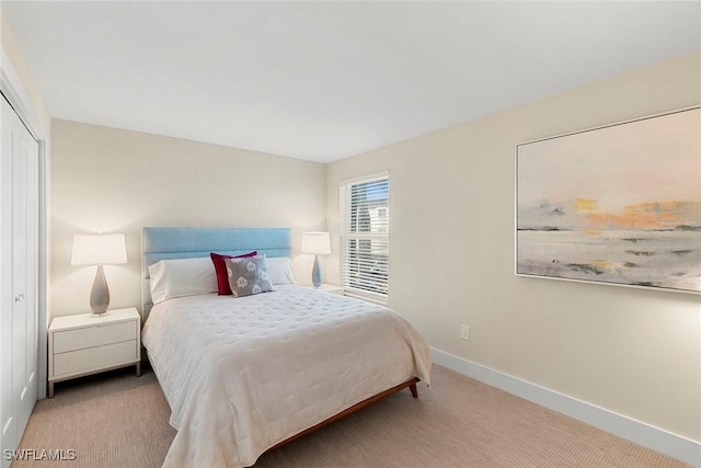 bedroom featuring light colored carpet and a closet