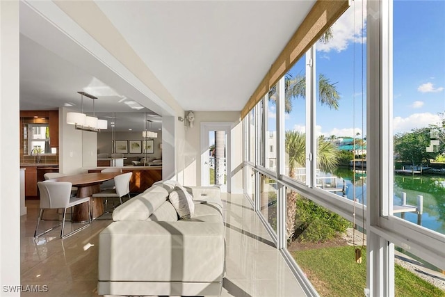 sunroom / solarium with a water view and sink