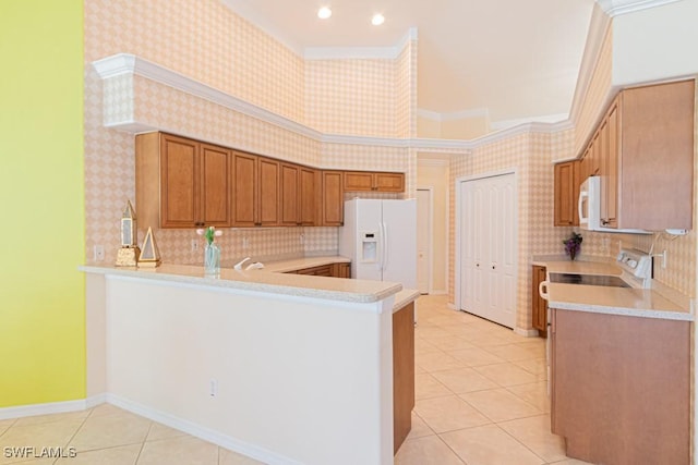 kitchen featuring tasteful backsplash, white appliances, kitchen peninsula, and light tile patterned floors