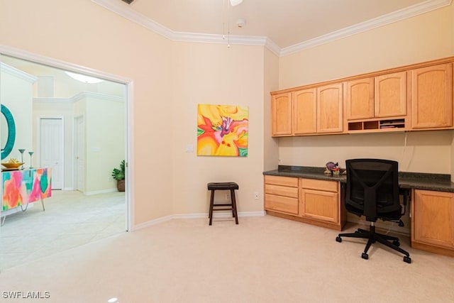 home office featuring light carpet, crown molding, and built in desk