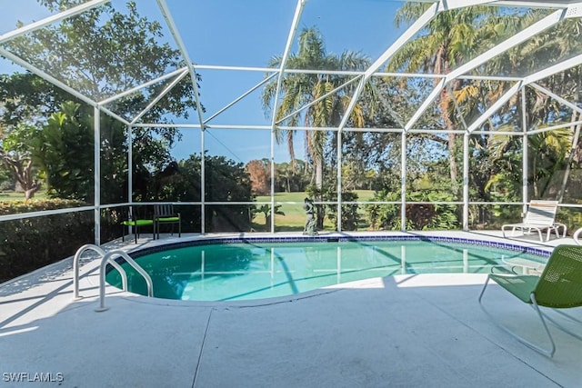 view of pool featuring glass enclosure and a patio area