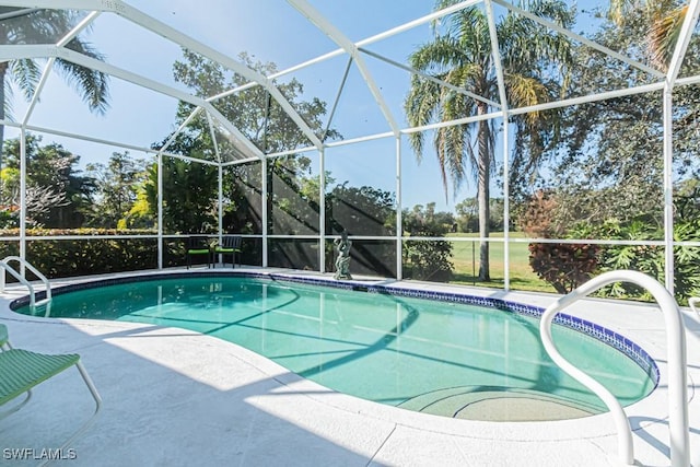 view of swimming pool featuring a patio area and glass enclosure