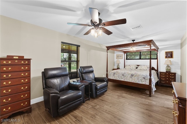 bedroom featuring multiple windows, wood-type flooring, and ceiling fan