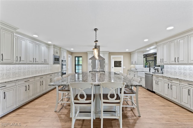 kitchen featuring a kitchen island, pendant lighting, a kitchen breakfast bar, decorative backsplash, and stainless steel appliances