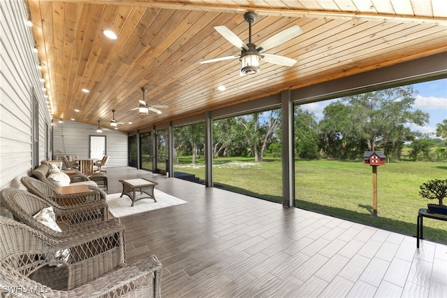 unfurnished sunroom featuring ceiling fan, a healthy amount of sunlight, and wooden ceiling