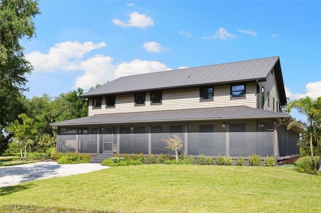 back of property featuring a lawn and a sunroom