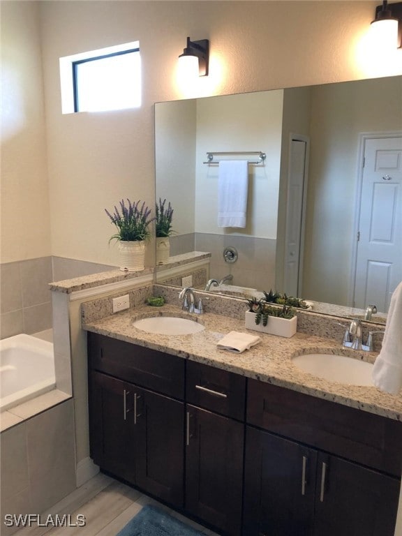 bathroom featuring vanity and tiled bath