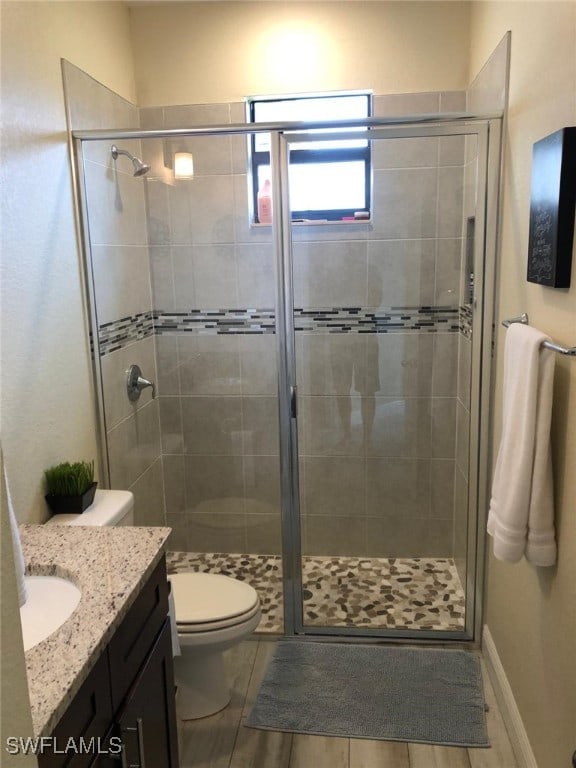 bathroom with vanity, toilet, and walk in shower